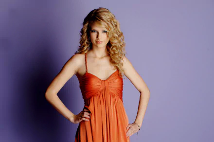 HD desktop wallpaper of American singer Taylor Swift in an orange dress with curly blonde hair, set against a plain purple background.