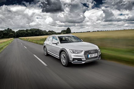 Silver Audi A4 driving on an open road under a dramatic cloudy sky, captured in 4K Ultra HD for a striking PC desktop wallpaper.
