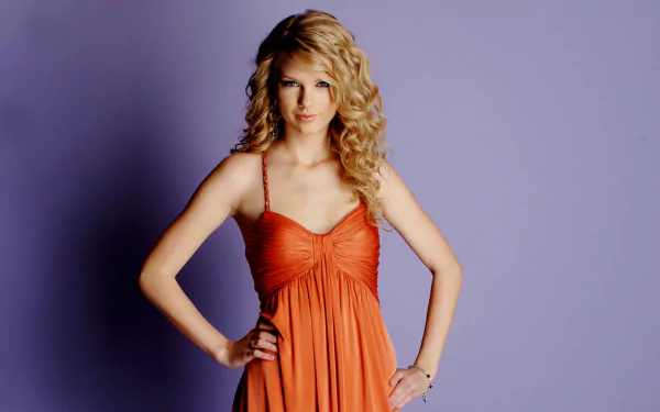 HD desktop wallpaper of American singer Taylor Swift in an orange dress with curly blonde hair, set against a plain purple background.