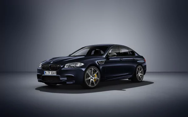 Sleek black BMW M5 sedan on a studio floor, high-detail car/vehicle 2K Quad HD PC desktop wallpaper and background.