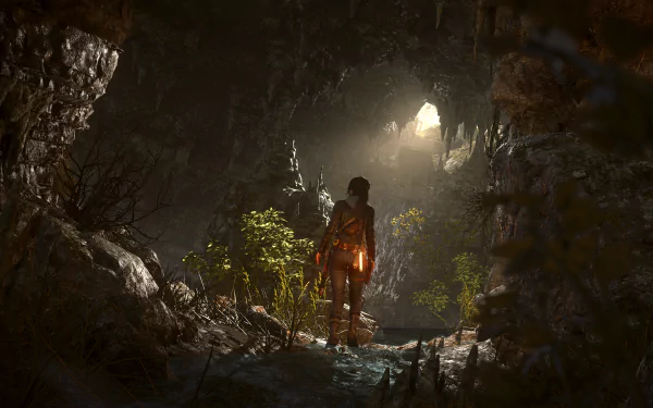 A scene from the video game Rise of the Tomb Raider, featuring a character exploring a dark cave illuminated by natural light, rendered in 8K Ultra HD for PC desktop.
