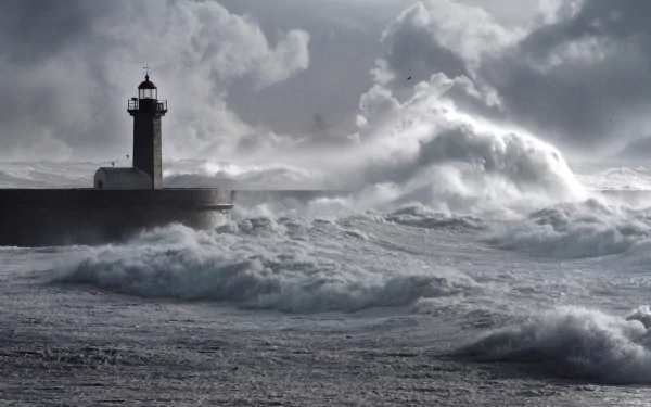 HD PC desktop wallpaper/background: towering waves crash against a man-made lighthouse on a stormy sea beneath brooding clouds.