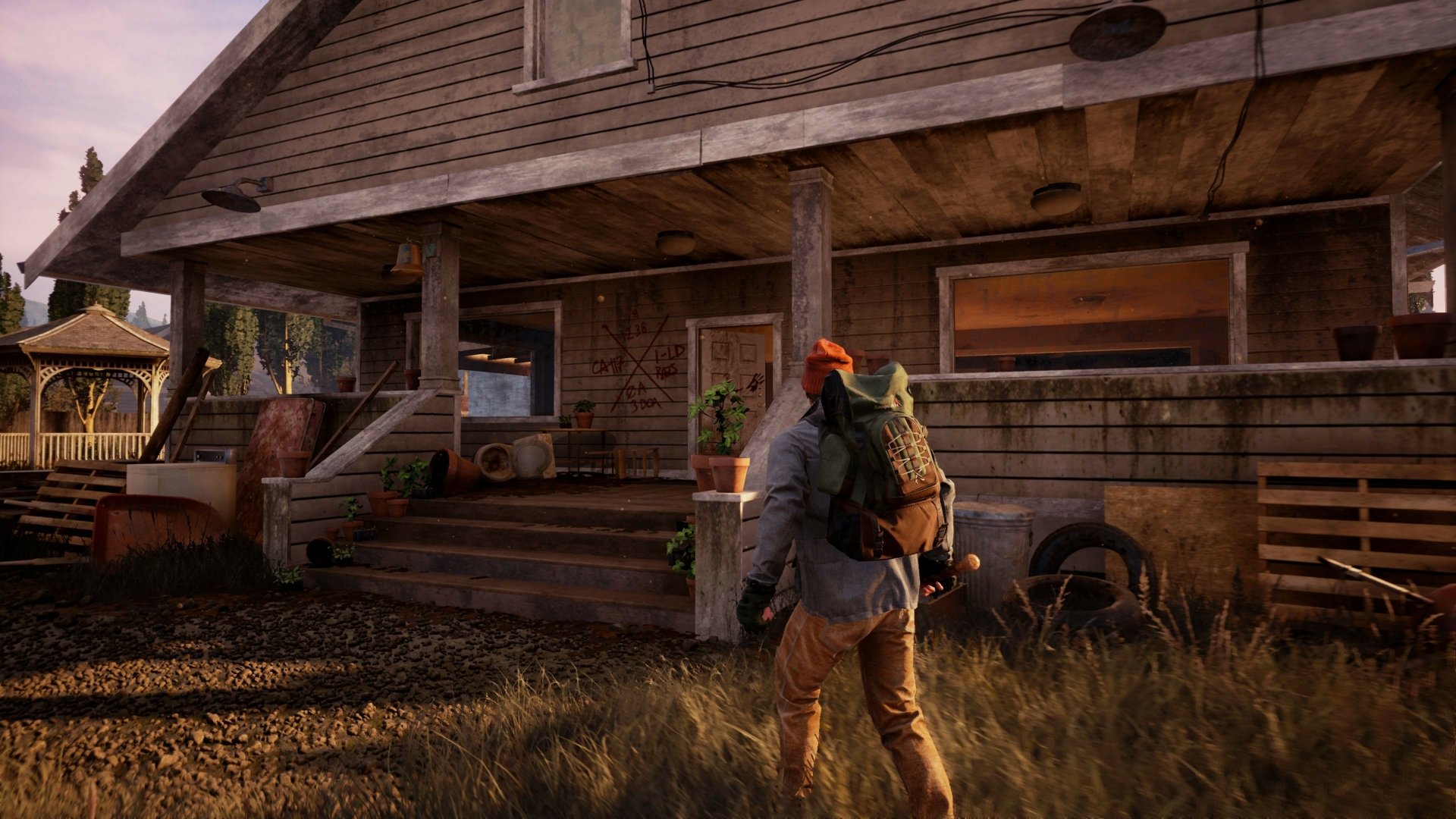 4K Ultra HD PC wallpaper from the video game State of Decay 2 showing a character with a backpack approaching a weathered wooden house.