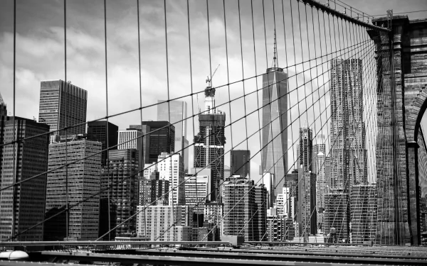 Black-and-white 5K Ultra HD PC desktop wallpaper of Manhattan skyscrapers framed by Brooklyn Bridge cables, New York skyline and man-made architectural skyline.