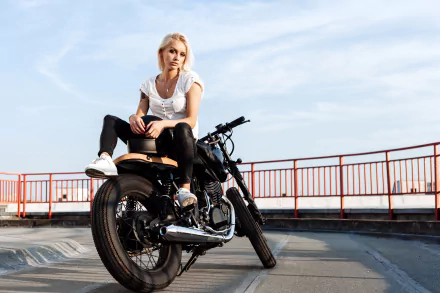 Blonde woman sitting confidently on a motorcycle against a clear sky, captured in 4K Ultra HD for a striking PC desktop wallpaper background.