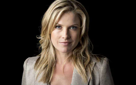 Close-up portrait of American actress Ali Larter with blue eyes and blonde hair against a black background, featured as an HD desktop wallpaper.