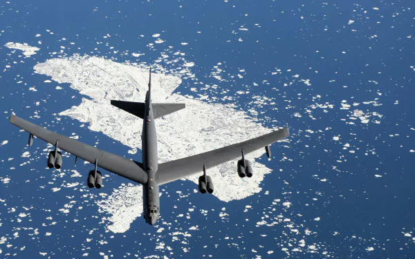 A Boeing B-52 Stratofortress bomber flies over icy waters, showcasing its military prowess in this stunning 4K Ultra HD desktop wallpaper.