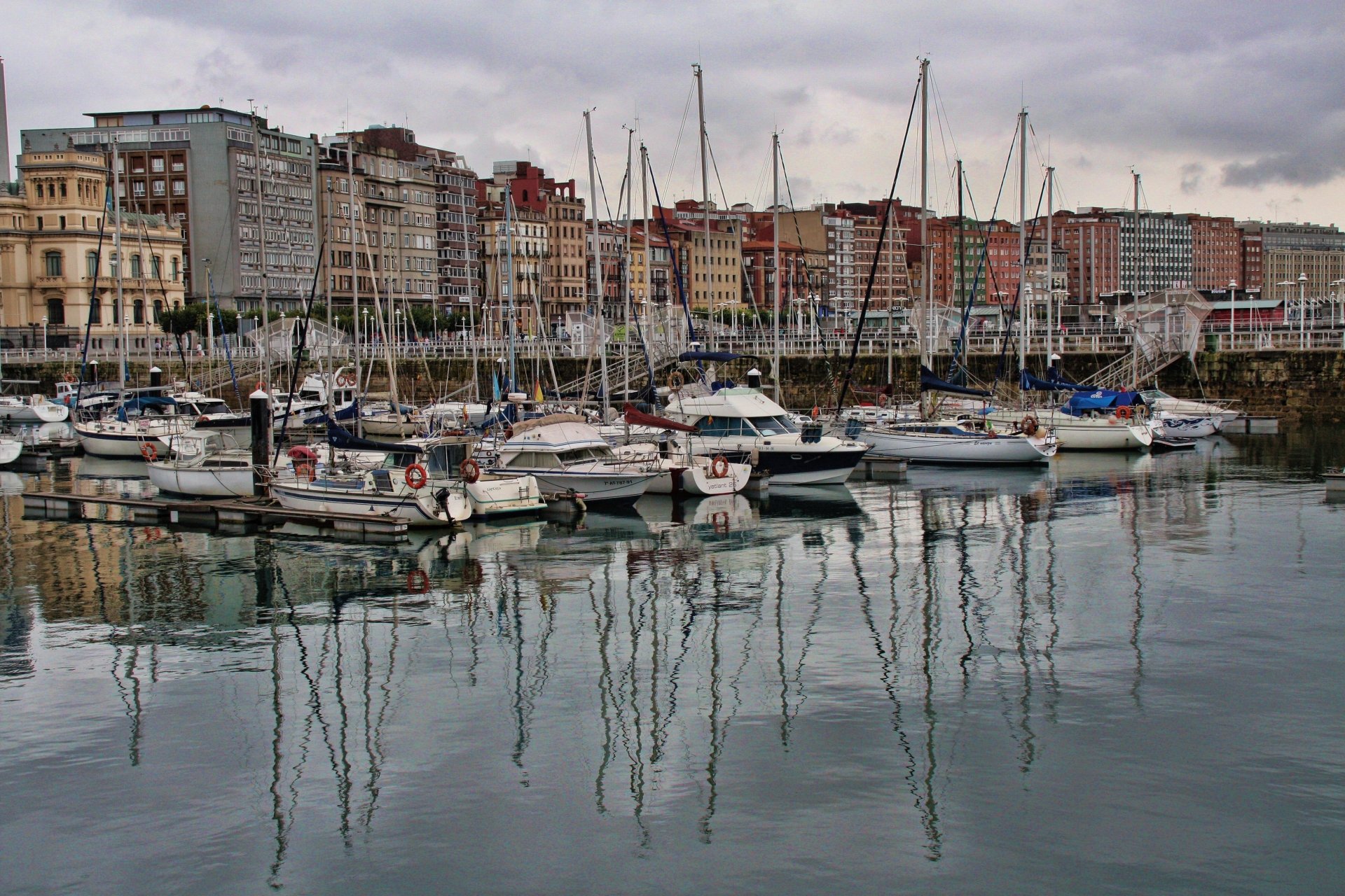 4K Ultra HD PC desktop wallpaper and background: man-made harbor with moored sailboats and reflected masts in calm water before multistory waterfront buildings.