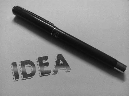 A black pen rests next to the word IDEA, presented in an inspirational, stylish font on a light background, creating a motivational atmosphere for this HD desktop wallpaper.