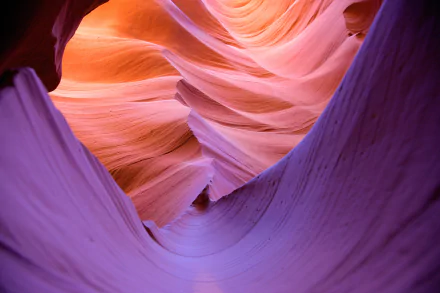 Vivid hues of orange and purple swirl through the breathtaking Antelope Canyon in Arizona, showcasing the stunning beauty of nature in this HD desktop wallpaper.