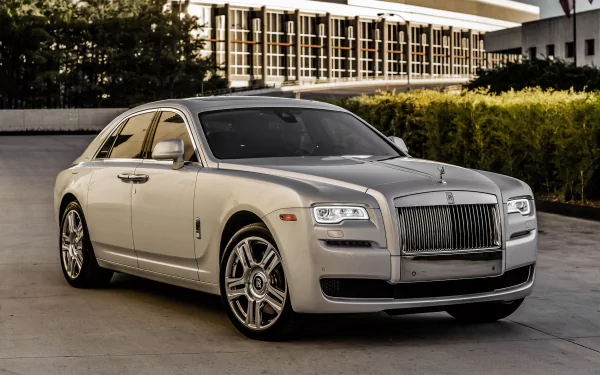 Silver Rolls-Royce Ghost parked outdoors, showcased in a 4K Ultra HD image highlighting the luxury vehicle’s sleek design and distinctive grille.