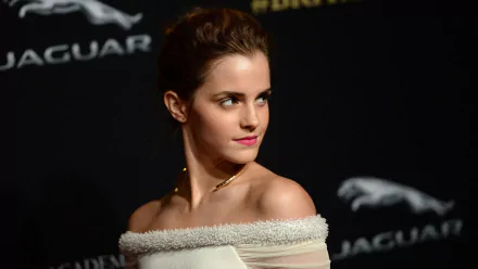 Emma Watson looking graceful in an elegant off-shoulder dress at a Jaguar event. This 4K Ultra HD wallpaper captures her poised presence and striking features.