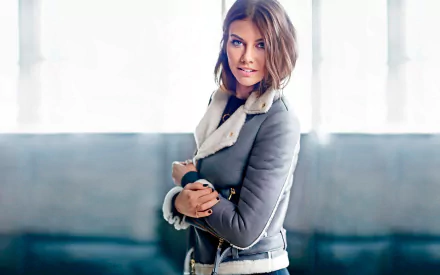 A captivating HD wallpaper featuring celebrity Lauren Cohan, showcasing her stylish pose against a bright, airy background.