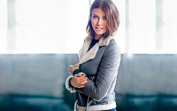 A captivating HD wallpaper featuring celebrity Lauren Cohan, showcasing her stylish pose against a bright, airy background.