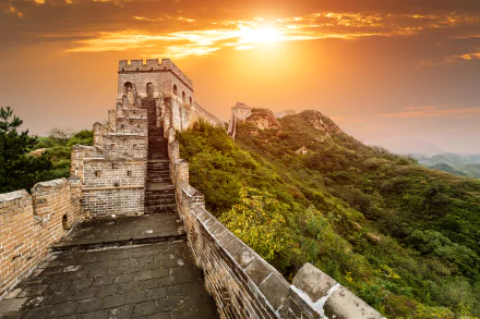 A stunning sunset over the Great Wall of China, showcasing its majestic man-made structure against a vibrant sky and lush landscape. Captured in vivid 4K Ultra HD detail.