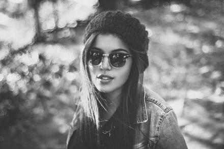 Black & white 5K Ultra HD PC desktop wallpaper: woman model wearing sunglasses and knit hat, sunlit bokeh background.