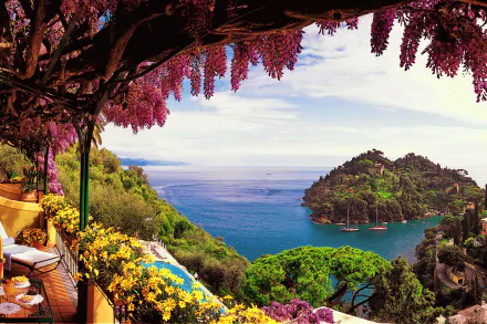 A vibrant terrace adorned with blooming flowers overlooks the serene Amalfi coastline, featuring islands and boats on the sparkling blue sea under a clear sky.