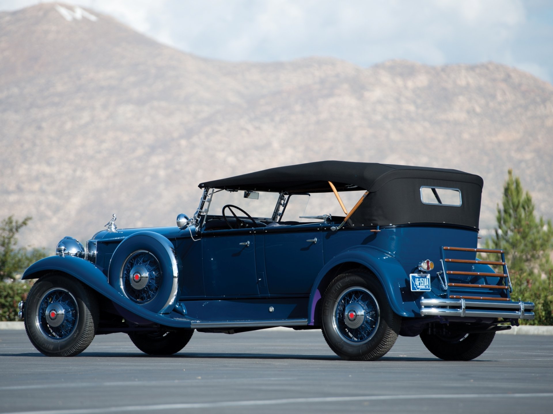 Blue Packard Deluxe Eight Sport Phaeton with folded black top against a mountain backdrop — HD PC desktop wallpaper/background featuring a classic vehicle.