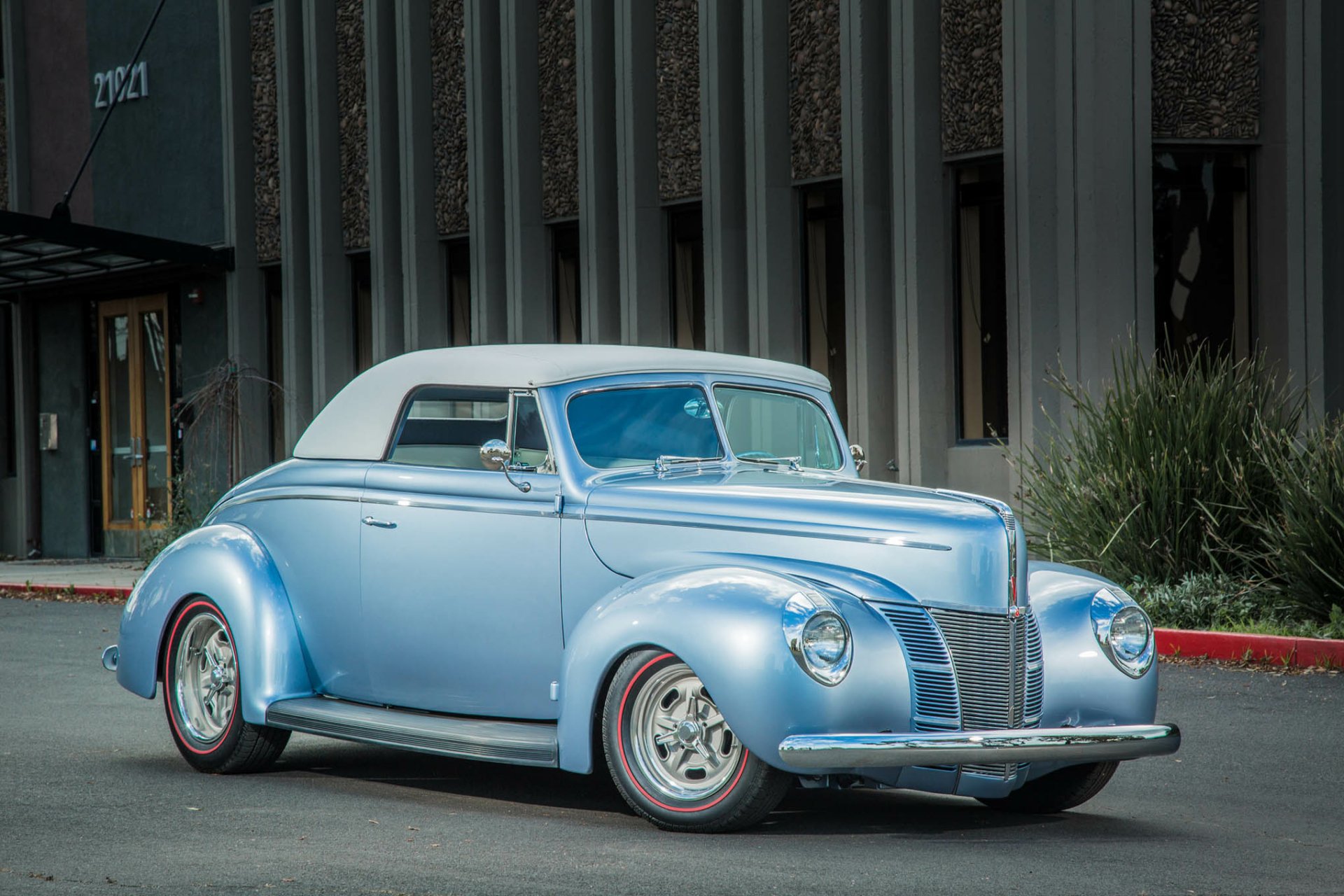 Light-blue 1940 Ford convertible hot rod parked by a building, vintage vehicle shown as HD PC desktop wallpaper background.