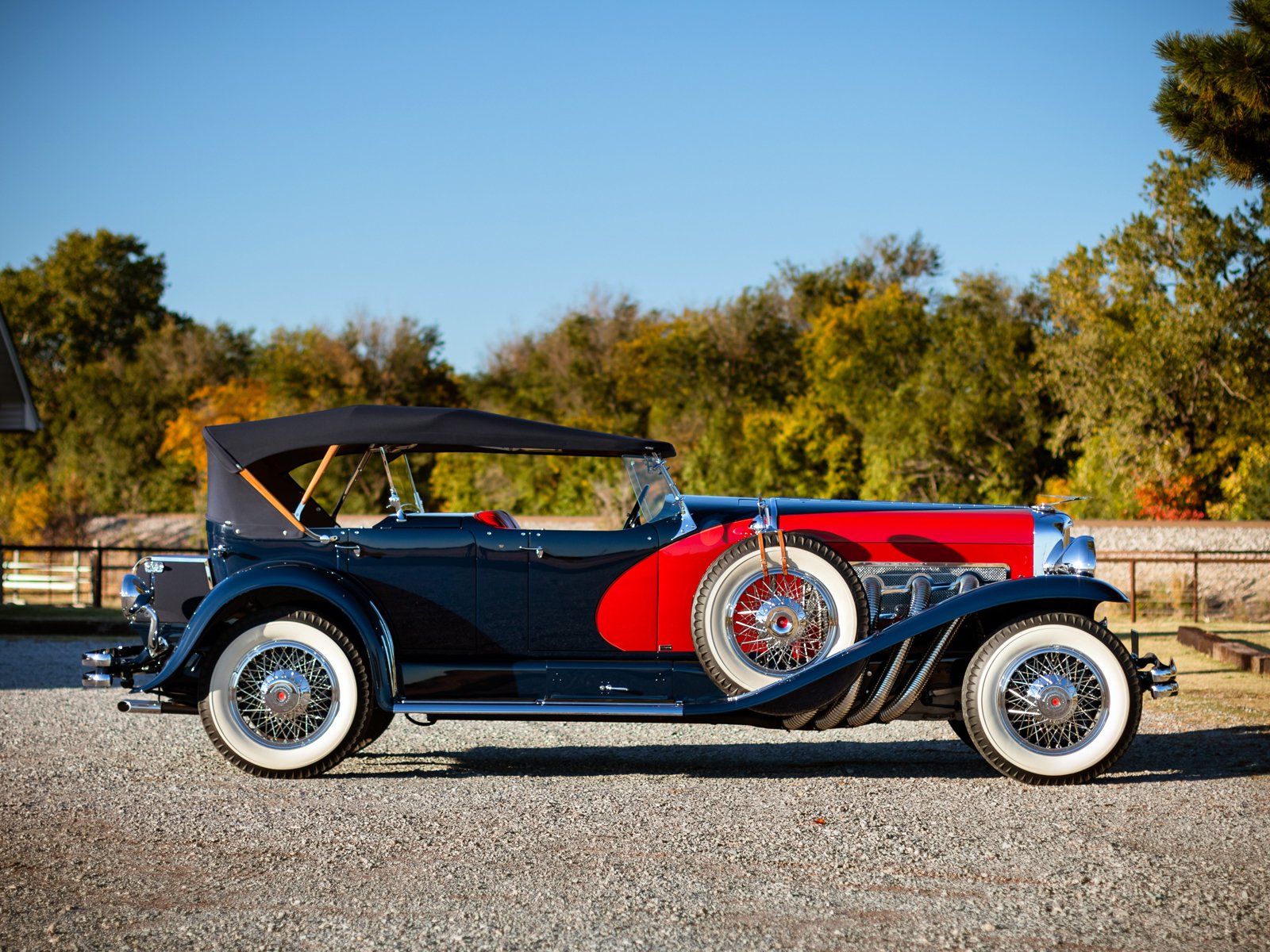 1929 Duesenberg Model J Dual Cowl Phaeton vintage car in profile against trees — HD PC desktop wallpaper/background.