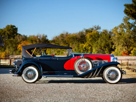 1929 Duesenberg Model J Dual Cowl Phaeton vintage car in profile against trees — HD PC desktop wallpaper/background.