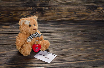 A plush teddy bear with a checkered bow holds a red heart-shaped lock beside a love note, set against a rustic wooden backdrop in 4K Ultra HD desktop wallpaper quality.