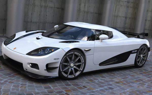 HD desktop wallpaper featuring a sleek white Koenigsegg CCXR supercar parked on a cobblestone surface, showcasing its modern design and sporty details.