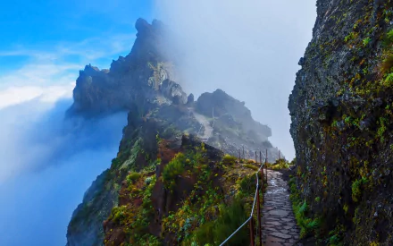 A man-made stone path winds along a misty mountain cliff in Portugal, captured in vibrant detail as an HD PC desktop wallpaper.