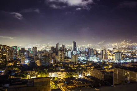 Nighttime cityscape of Medellin, Colombia, showcasing illuminated buildings and urban lights in a vibrant 4K Ultra HD view.