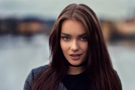 A high-definition desktop wallpaper featuring Veronika Ožanová, a brunette model with blue eyes, posing with a confident expression against a softly blurred background.