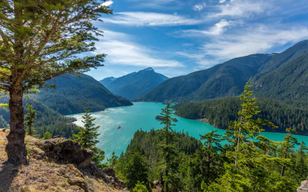 HD desktop wallpaper showcasing Diablo Lake surrounded by forested mountains under a vibrant blue sky, capturing the beauty of nature.