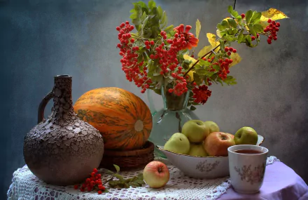 Still life HD desktop wallpaper featuring a ceramic pitcher, pumpkin, apples in a bowl, a cup of tea, and red berries arranged on a lace-covered table in a fall-themed setting.