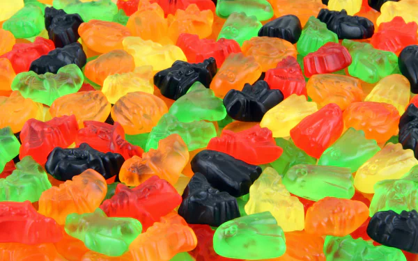 Vibrant assortment of colorful gummy candies in various shapes and colors, captured in sharp 4K Ultra HD, creating a lively and detailed food-themed desktop wallpaper.