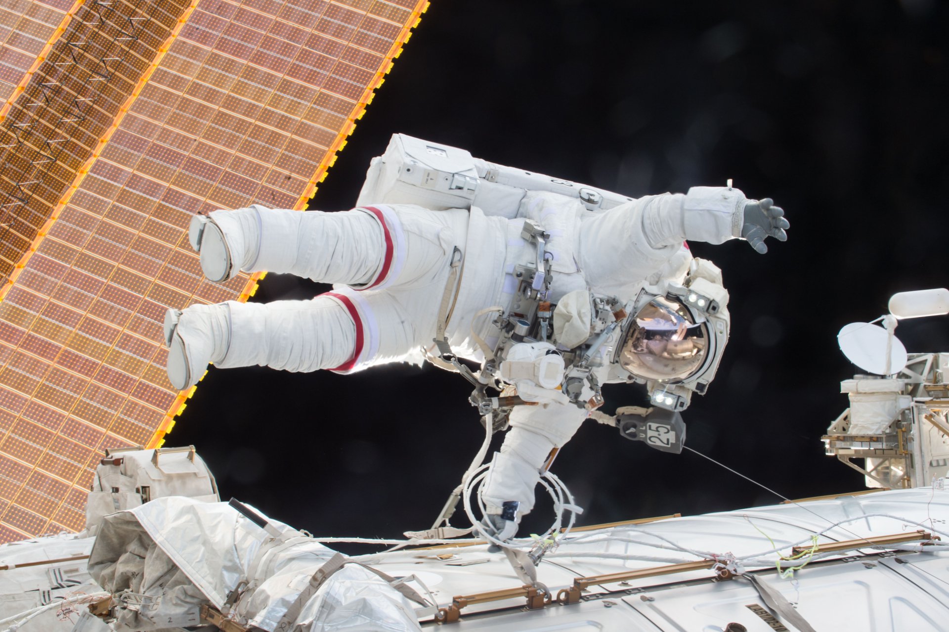 4K Ultra HD PC desktop wallpaper: NASA astronaut on a spacewalk beside a man-made space station and solar panels, floating against the black void of space.
