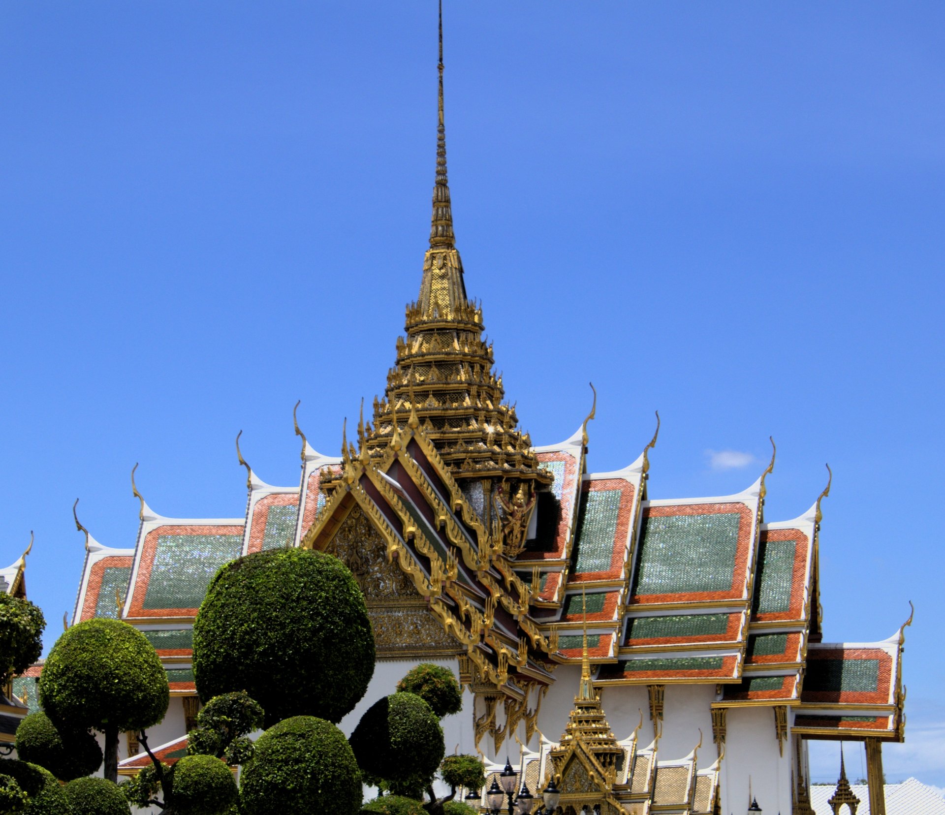 4K Ultra HD image of a man-made palace in Thailand featuring intricate roof details and a clear blue sky background.
