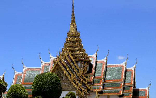 4K Ultra HD image of a man-made palace in Thailand featuring intricate roof details and a clear blue sky background.
