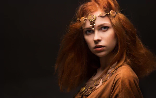 4K Ultra HD desktop wallpaper: redhead model with blue eyes wearing an ornate necklace against a dark, moody background.
