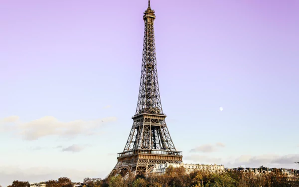 4K Ultra HD image of the man-made Eiffel Tower monument in Paris, France, standing tall against a soft purple sky.