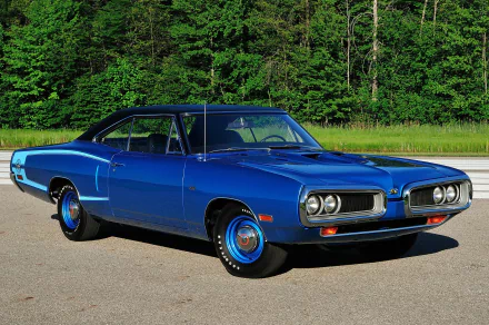A vibrant blue Dodge Coronet Super Bee Hardtop Coupe parked on pavement with lush green trees in the background, shown in an HD PC desktop wallpaper style.
