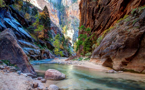 4K Ultra HD desktop wallpaper featuring a serene river winding through a rocky canyon surrounded by lush trees and vibrant natural scenery.