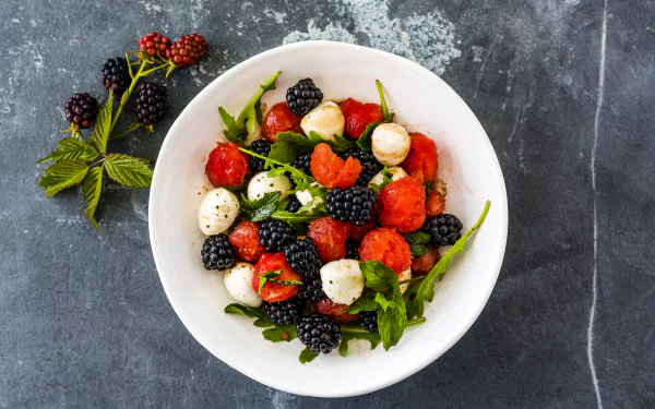 5K Ultra HD PC desktop wallpaper: overhead bowl of mixed fruit — blackberries, raspberries, mozzarella and greens — vivid berry food close-up.