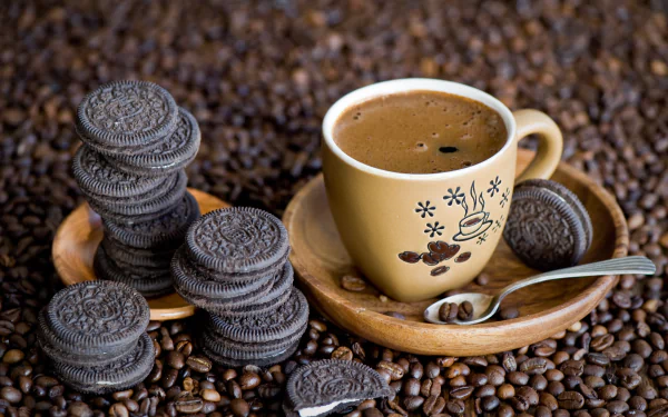 A 4K Ultra HD desktop wallpaper featuring a cup of coffee surrounded by Oreo cookies and coffee beans on a rustic wooden plate.