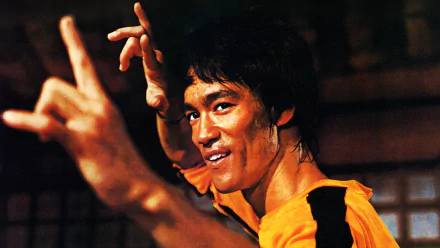 HD desktop wallpaper of Bruce Lee in a martial arts stance from the movie Game of Death, showcasing his iconic yellow jumpsuit and intense expression.