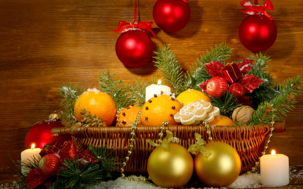 4K Ultra HD PC desktop wallpaper: colorful Christmas holiday scene with glowing candles, a wicker basket of oranges and cookies, evergreen sprigs and red and gold Christmas ornaments.