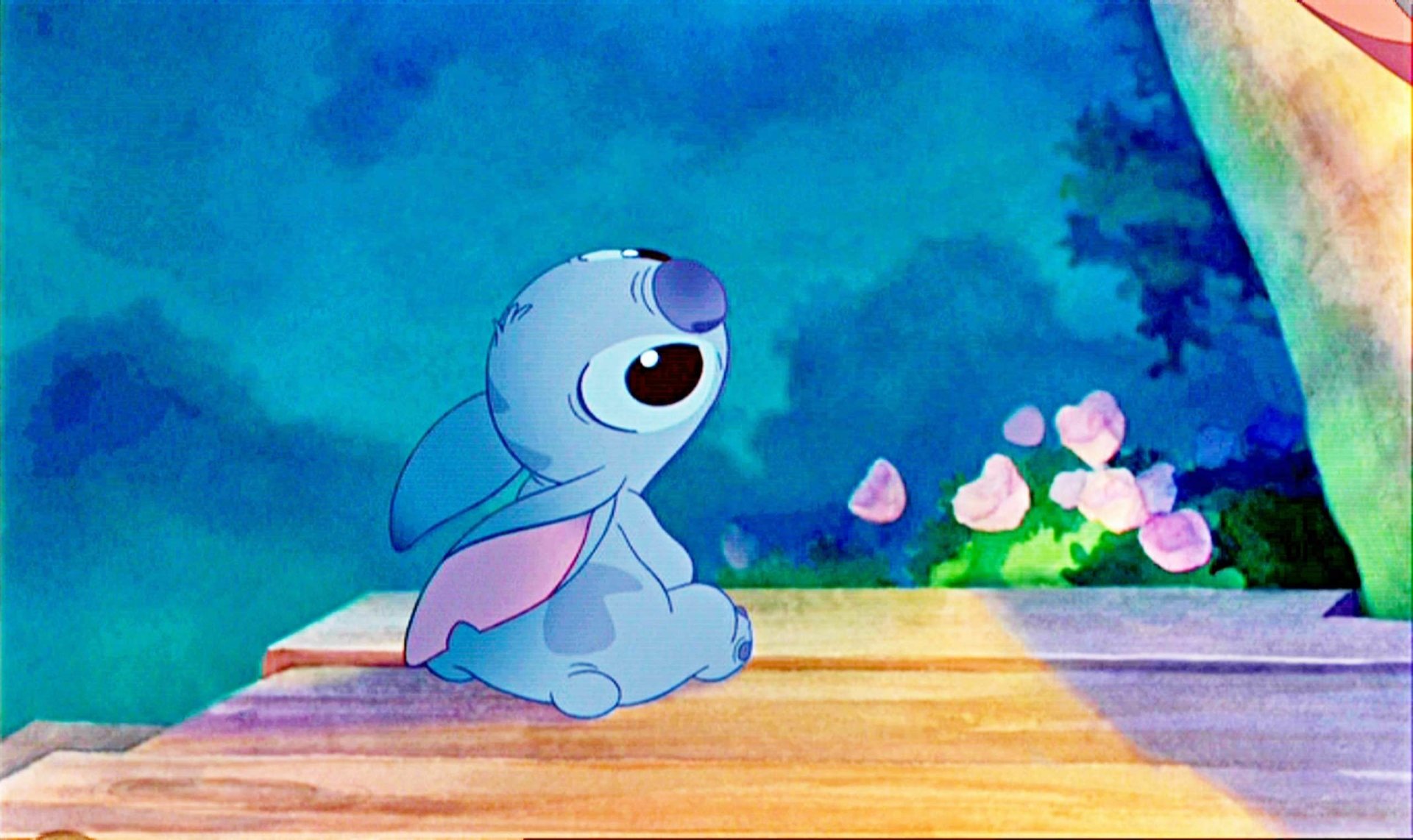 HD desktop wallpaper featuring Stitch from Lilo & Stitch, seated with a whimsical background.
