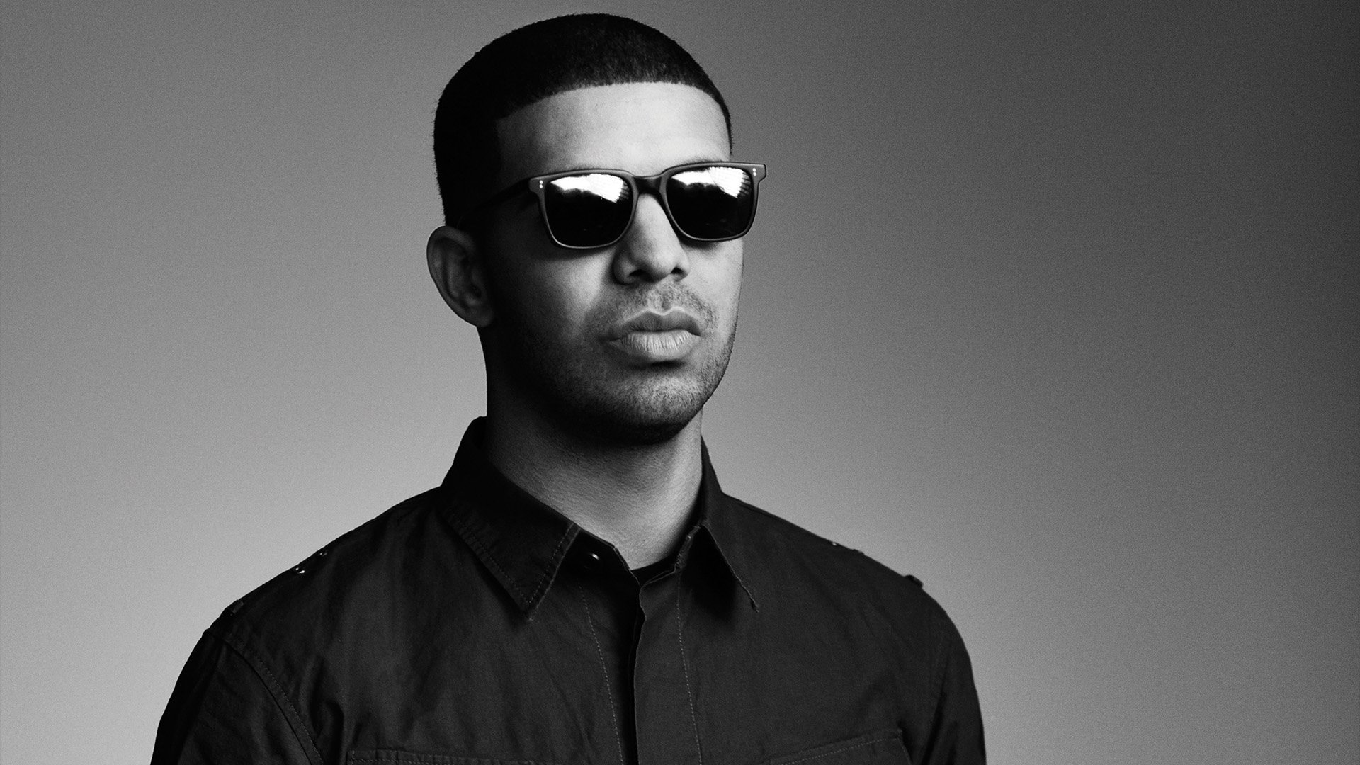 HD desktop wallpaper featuring a monochrome portrait of a man in sunglasses and a black shirt, providing a stylish background.