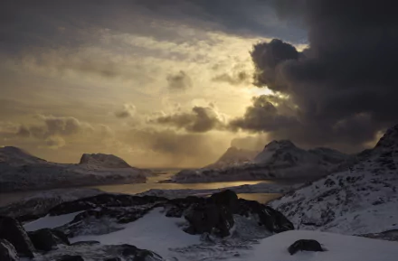 HD image of a dramatic Lofoten landscape, captured through photography, showcasing snow-covered mountains under a moody sky.