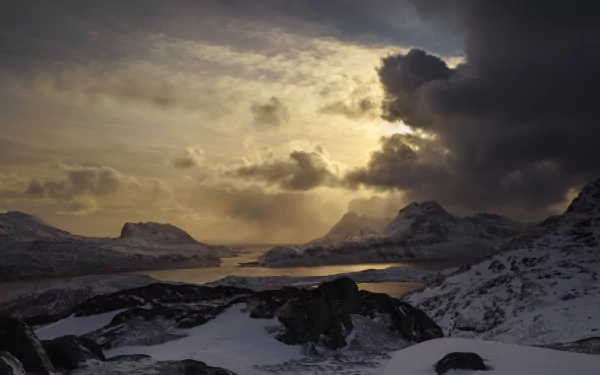 HD image of a dramatic Lofoten landscape, captured through photography, showcasing snow-covered mountains under a moody sky.