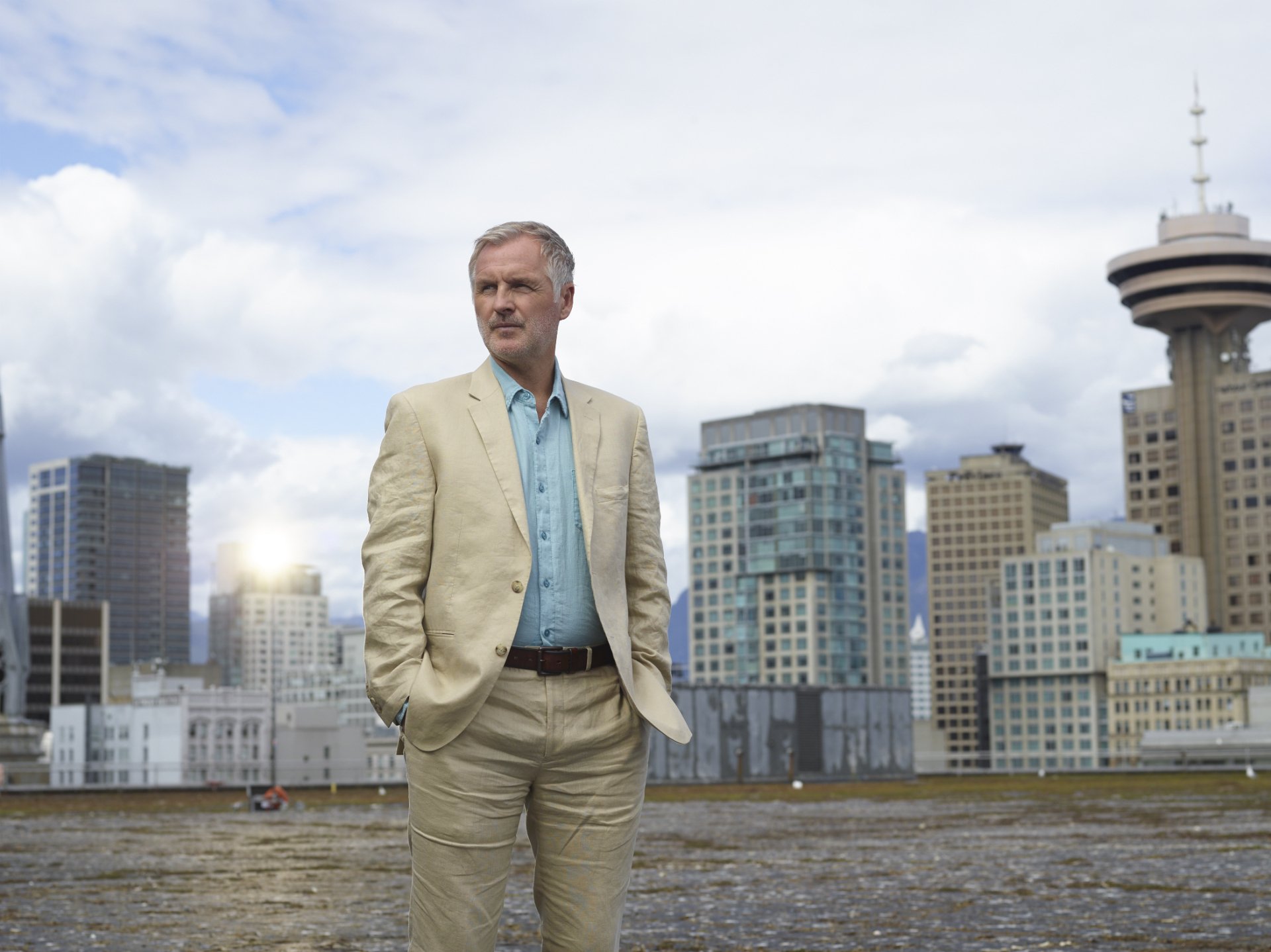 HD desktop wallpaper featuring Andrew Airlie with a city skyline and cloudy sky in the background.