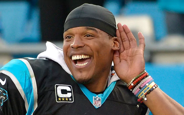 HD desktop wallpaper featuring a smiling man in a football uniform with the captain's patch, engaging with someone off-camera.